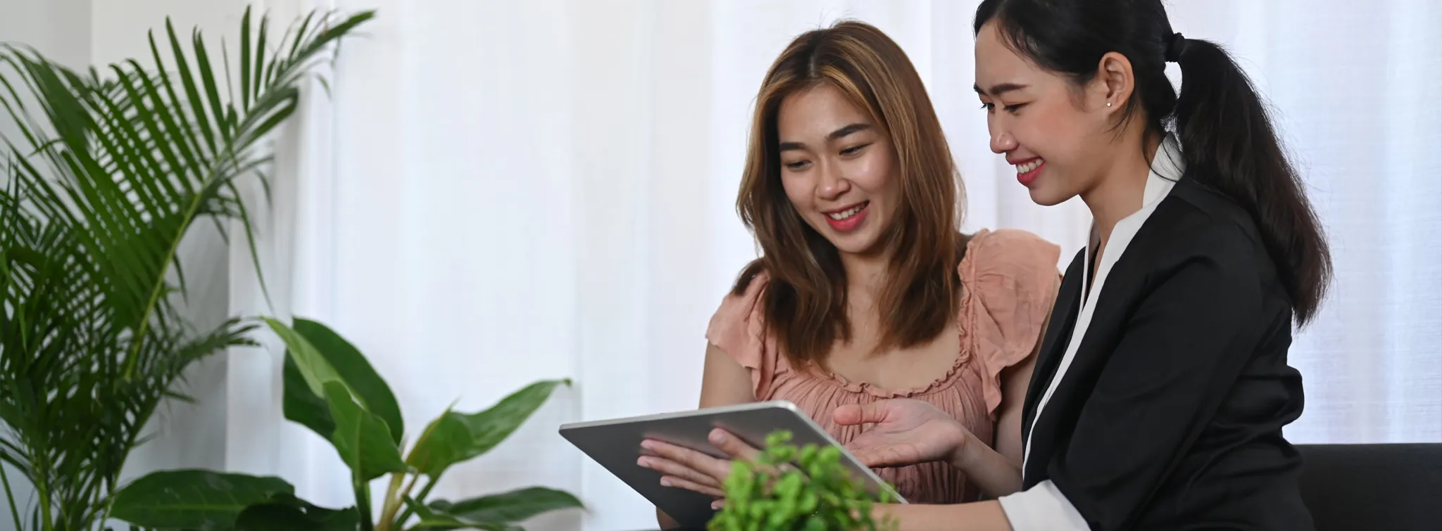 two women looking over digital paperwork on a tablet device