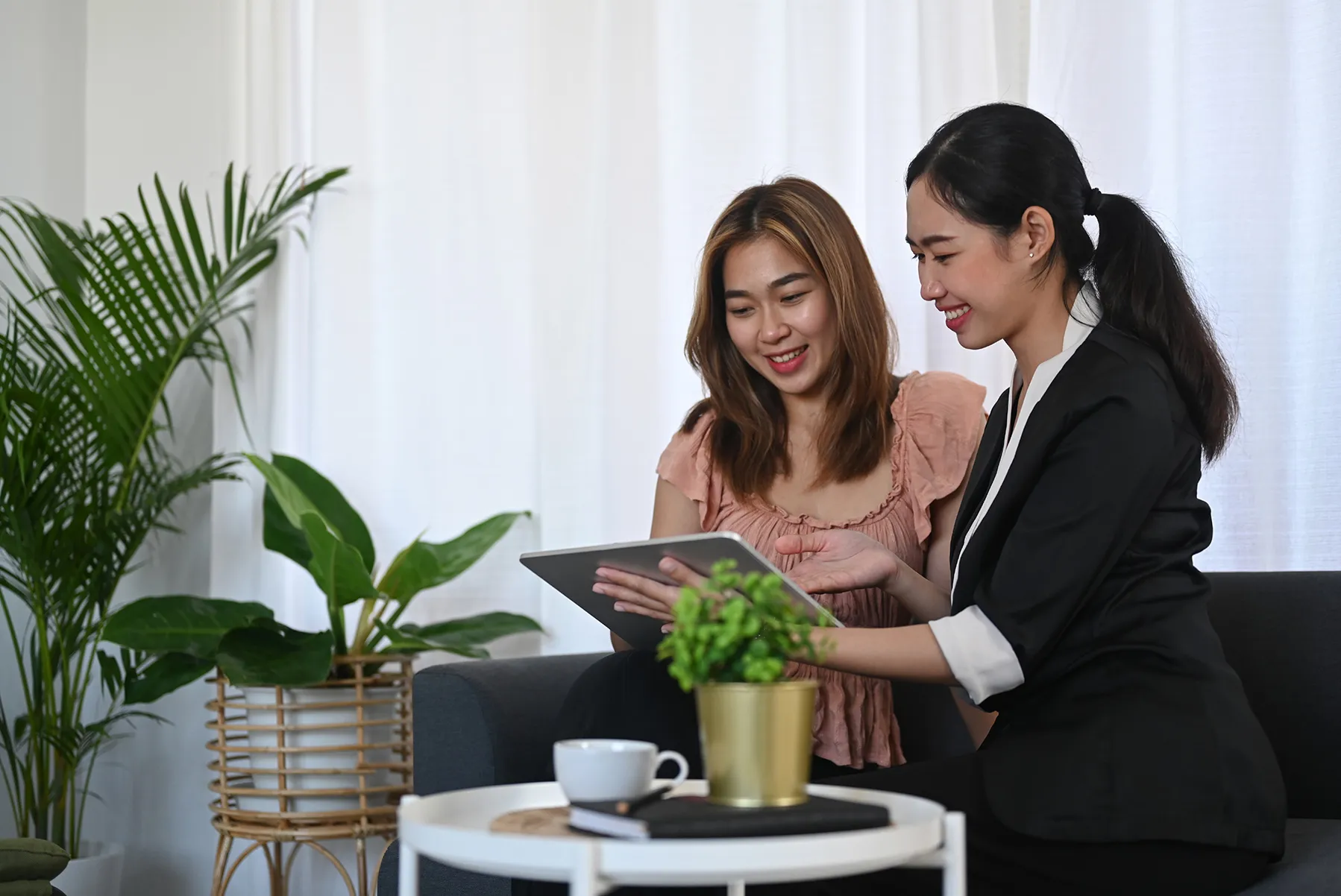 two women looking over digital paperwork on a tablet device